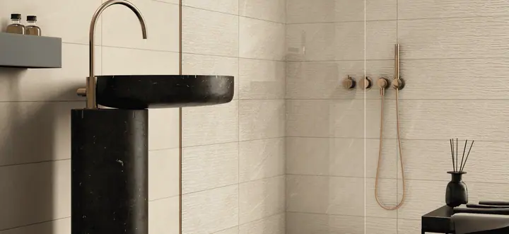 Badkamer met beige Polis Volcano wandtegels en zwarte staande wastafel